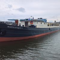 MS Magnifique I Flusskreuzfahrtschiff am Hafen festgemacht mit dunkelblauem Rumpf, weißem Aufbau und rotem Wasserlinienstrich.