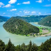 Luftaufnahme der Schlögener Schlinge, wo die Donau dramatisch um eine bewaldete Halbinsel in Österreich fließt.