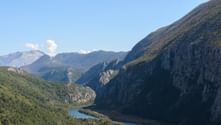 Luftaufnahme der Cetina-Schlucht mit türkisfarbenem Fluss, der sich durch steile Felsklippen mit grüner Vegetation schlängelt.