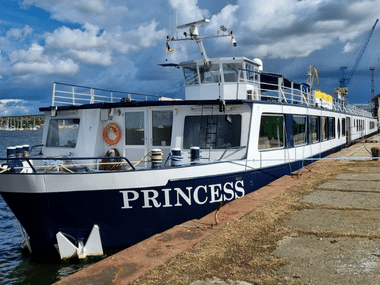 Weiß-blaues Fahrgastschiff namens Princess am Kai im Hafen von Stralsund unter bewölktem Himmel.