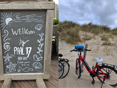 Kreidetafel mit 'Welkom bij Paal 17 aan zee' und Stranddekorationen, neben roten Fahrrädern auf sandigen Dünen mit Gras unter bewölktem Himmel.