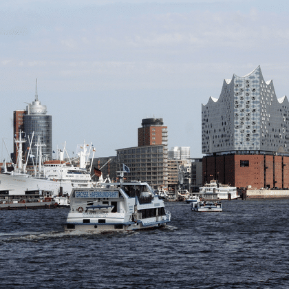 Blick auf den Hamburger Hafen mit Fährschiffen auf der Elbe. Die markante Elbphilharmonie prägt die Skyline.