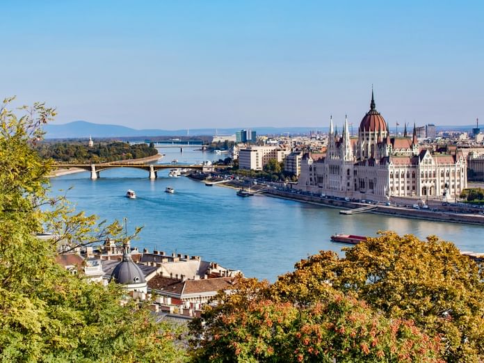 Panoramablick auf Budapests Stadtteil Pest mit dem ungarischen Parlamentsgebäude und seiner markanten Kuppel entlang der Donau mit Brücke.